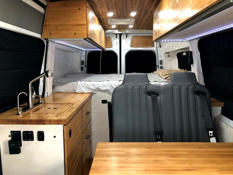 Explore this modern rv rental camper van: featuring a full kitchen, comfortable bed, and versatile seating area.