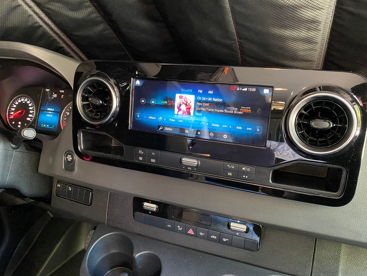 RV rental dashboard with high-tech infotainment playing SiriusXM, showing 43k miles and climate settings.