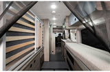 RV rental interior: cozy camper van with wood-slat bed, compact kitchen, and front cab view. Ready for adventure.