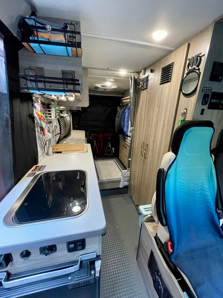 Explore a compact rv rental camper van interior: equipped kitchen, smart storage, and cozy seating for your next mobile adventure.
