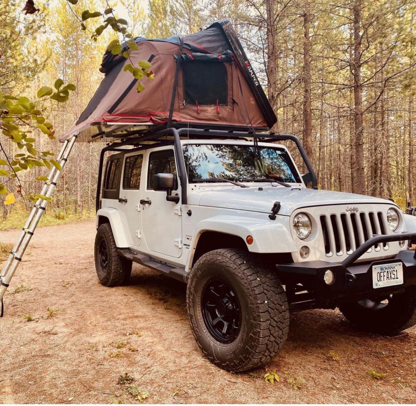  ready for an RV rental adventure.|White Jeep with rooftop tent on dirt road in sunlit forest. Ideal RV rental for off-grid camping adventures and outdoor escape.|White Jeep Wrangler with a rooftop tent on a rocky riverbed. Your ideal RV rental for outdoor adventures!|An RV rental showing a Jeep with a deployed iKAMPER rooftop tent — photo 2