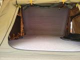 Comfortable interior of an RV rental rooftop tent, featuring a quilted mattress and walls for a cozy sleep.