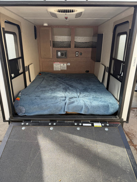 Inside an RV rental: cozy bed, overhead storage, and climate control for comfortable mobile living.