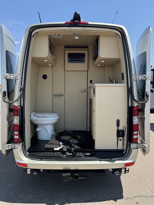 Rear view of an RV rental's interior: compact kitchen, toilet, and storage. Ideal for road trips. — photo 15