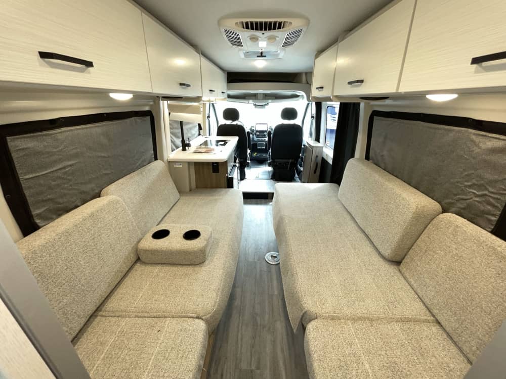 Modern camper van interior, perfect for your RV rental road trip. Features comfy seating, dinette, and ample storage.