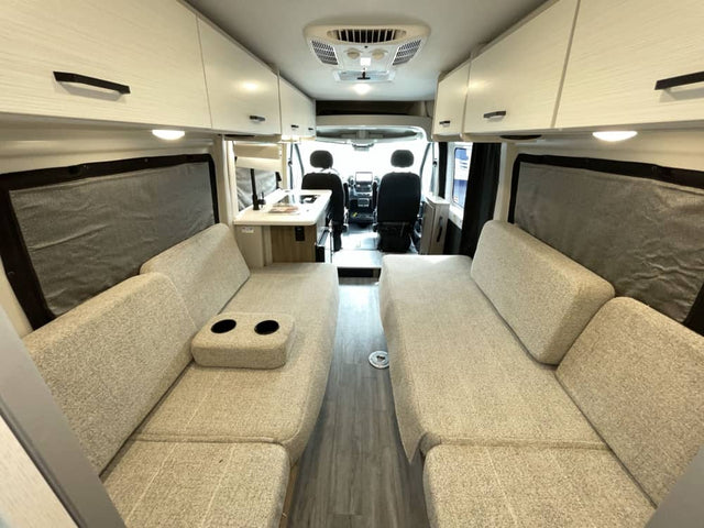 Modern camper van interior, perfect for your RV rental road trip. Features comfy seating, dinette, and ample storage.