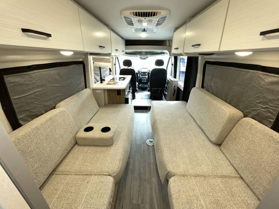 Modern camper van interior, perfect for your RV rental road trip. Features comfy seating, dinette, and ample storage.