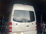 This Roadtrek Mercedes-Benz Sprinter camper van, parked indoors, is an ideal rv rental for your next trip.