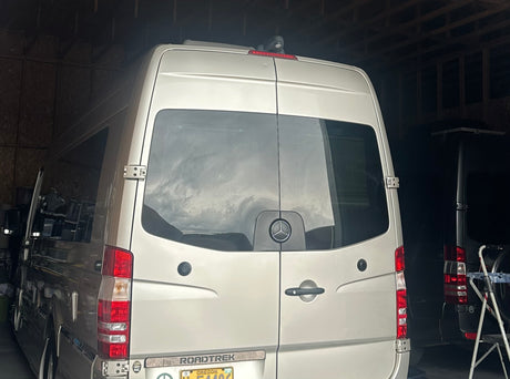 This Roadtrek Mercedes-Benz Sprinter camper van, parked indoors, is an ideal rv rental for your next trip.