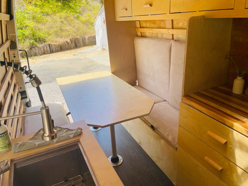 Custom RV rental interior featuring a cozy dining area with table, bench, and a practical kitchen sink. — photo 13
