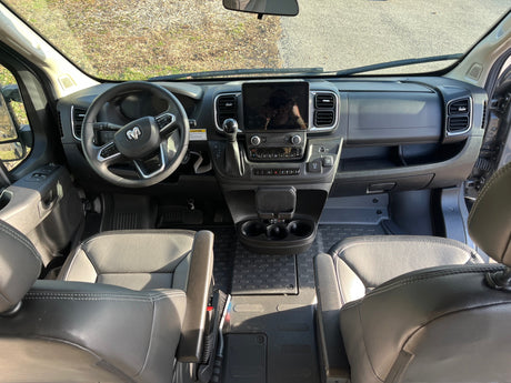 Spacious RV rental cockpit with modern dashboard, large infotainment screen, and comfortable seating, ideal for road trips.