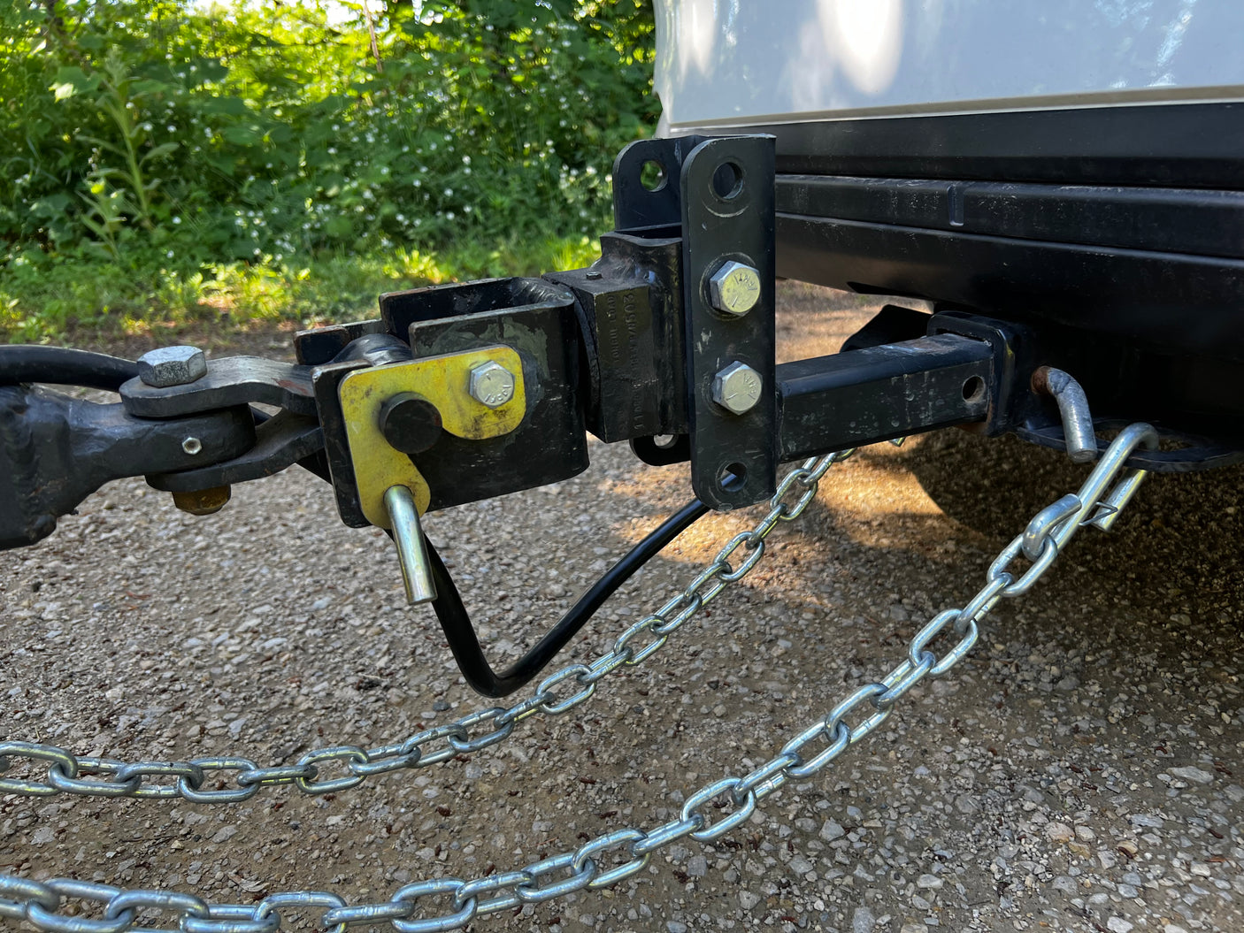 Secure RV rental trailer hitch connection with safety chains and weight distribution components for safe towing.
