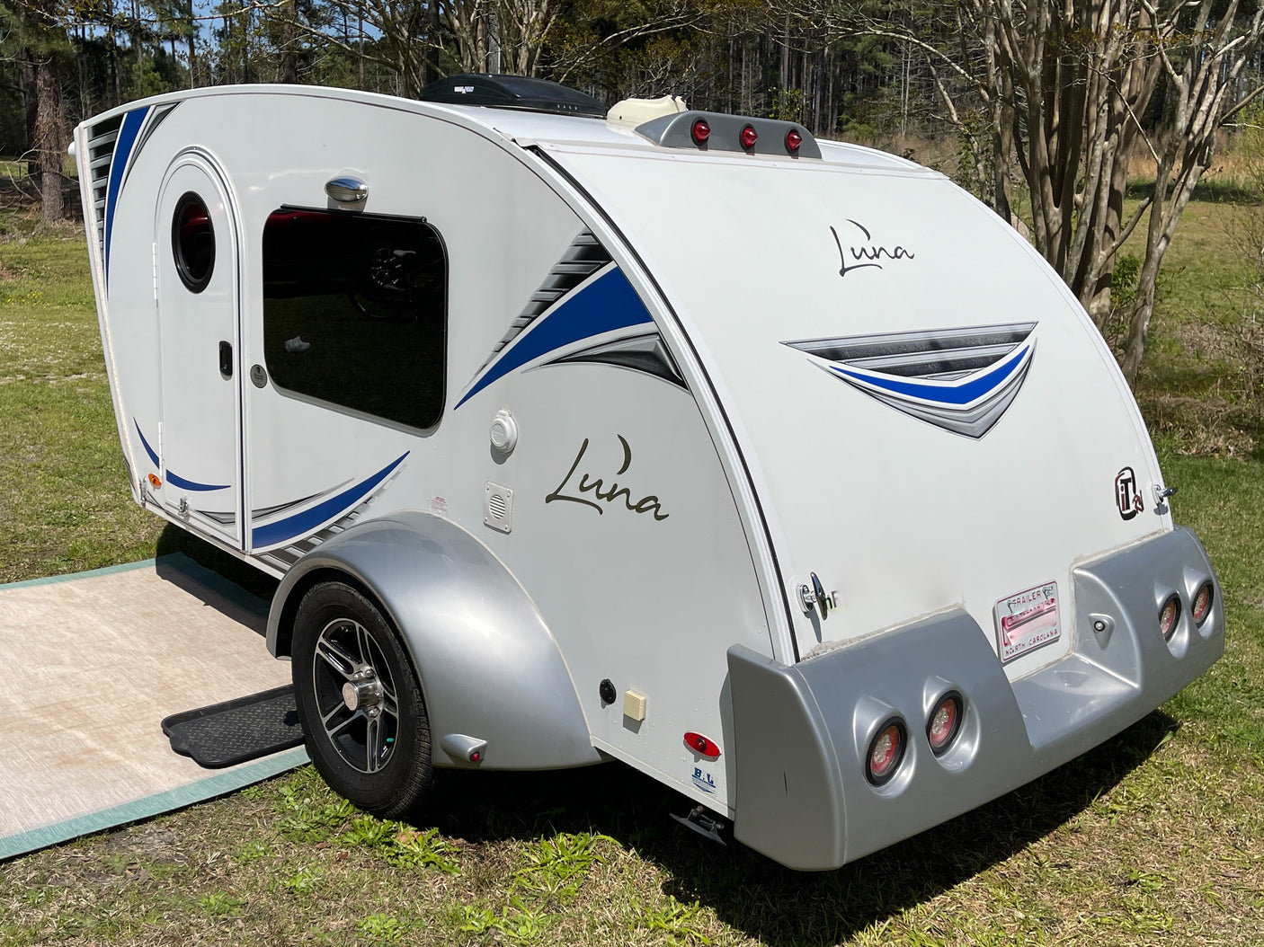 This white Luna teardrop RV camper with blue accents is ready for your next rv rental outdoor adventure.