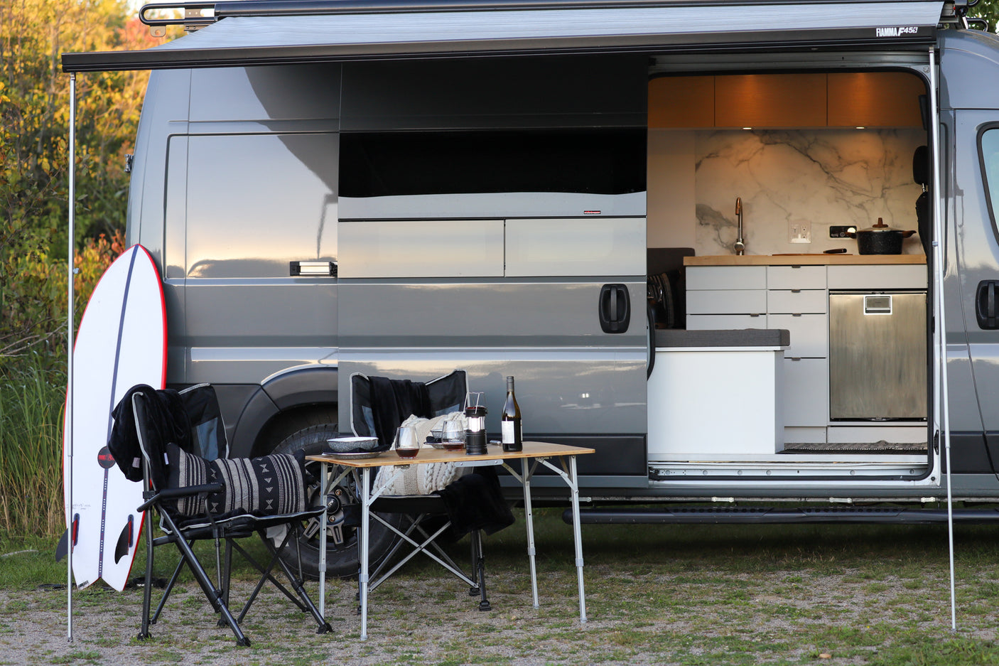 Experience the ultimate freedom with an **rv rental**. This camper van features a modern interior kitchen and cozy outdoor living setup with surf gear.