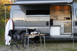 Experience the ultimate freedom with an **rv rental**. This camper van features a modern interior kitchen and cozy outdoor living setup with surf gear.