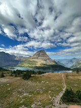 Sweeping view of a grand mountain, clear lake, and forest. An RV rental makes exploring this stunning natural landscape easy!