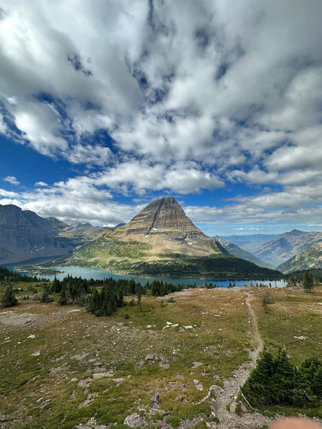 Sweeping view of a grand mountain, clear lake, and forest. An RV rental makes exploring this stunning natural landscape easy!