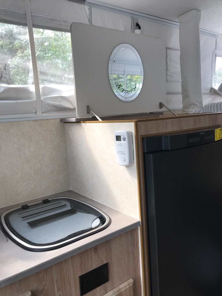  and a two-burner stovetop on a grey counter. Ideal for mobile cooking.|This compact RV rental kitchenette features a sink — photo 7