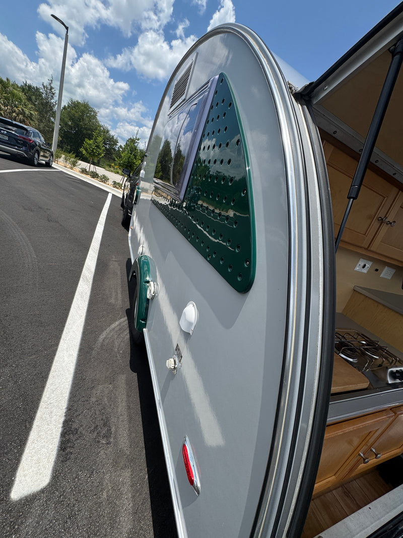 Explore with this stylish gray and green teardrop RV rental! Rear hatch open reveals compact kitchen; parked on asphalt. — photo 7