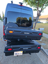 Back of an RV rental van with a mounted spare tire, two stacked Yakima cargo boxes, and a California license plate.