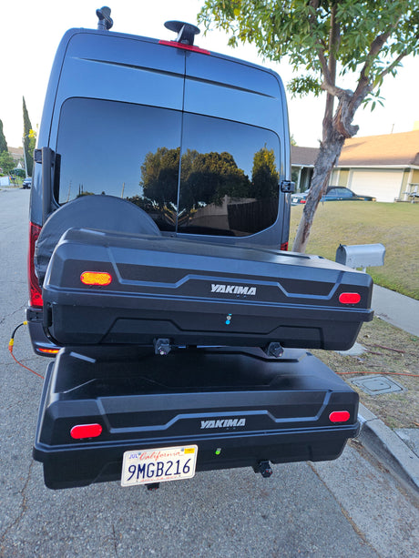 Back of an RV rental van with a mounted spare tire, two stacked Yakima cargo boxes, and a California license plate.