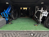 RV rental adventure! Two e-bikes (blue, white) secured in a vehicle's carpeted cargo area, perfect for outdoor transport & camping.