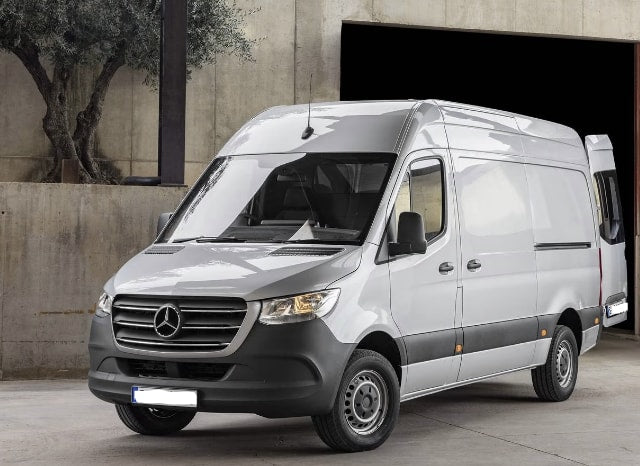 A light gray Mercedes Sprinter van, often used for RV rental conversions, parked outdoors near a garage entrance. — photo 2