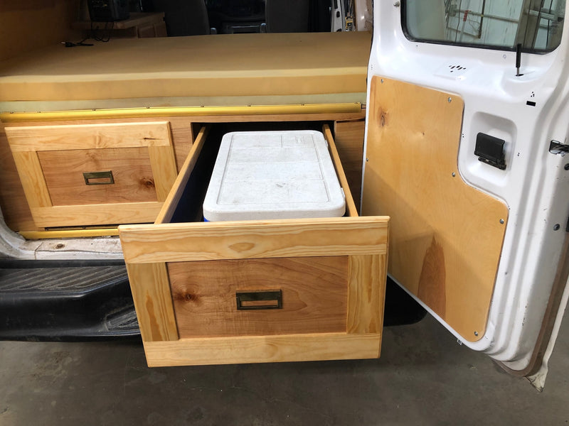 RV rental custom storage: wood drawers with a cooler inside a camper van. Foam bed & open door. — photo 10