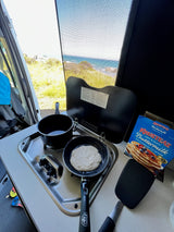 RV rental breakfast: Pancakes cooking on the stovetop with a beautiful ocean view.