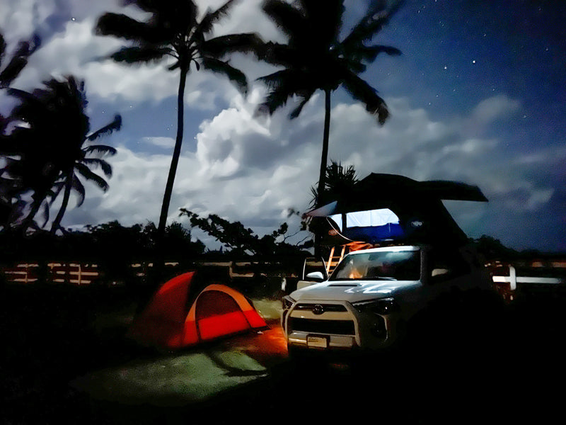 Night camping adventure with an RV rental! White SUV with rooftop tent, orange ground tent, and palm trees under starry clouds. — photo 13