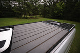 RV rental featuring roof solar panels and spacious deck for off-grid camping and outdoor living.