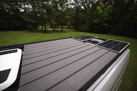 RV rental featuring roof solar panels and spacious deck for off-grid camping and outdoor living.
