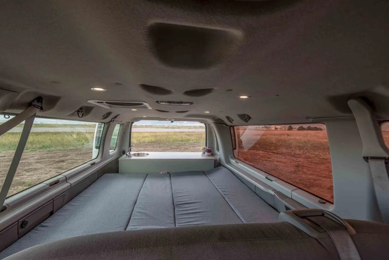  and water tanks for mobile adventures.|Compact camper van kitchen with pull-out stove and sink — photo 10