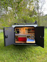 Open rear galley of a compact rv rental camper, revealing kitchen, cooler, & storage for outdoor trips.
