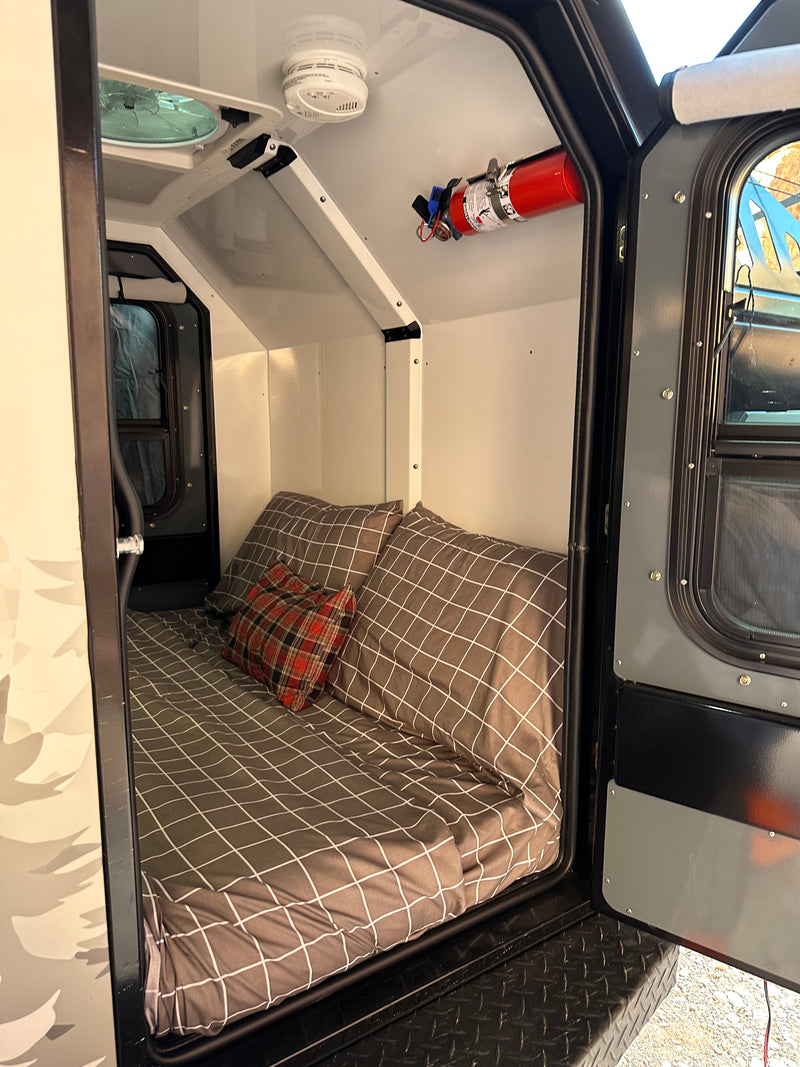 Cozy compact **RV rental** interior with a bed, fan, and safety features like a smoke detector and fire extinguisher. — photo 3