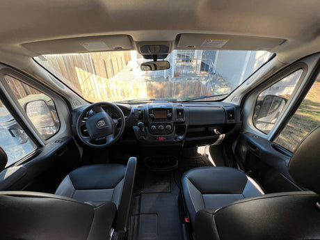 Inside this RV rental van: driver's area, dashboard, and steering wheel are visible. Ready for your journey!