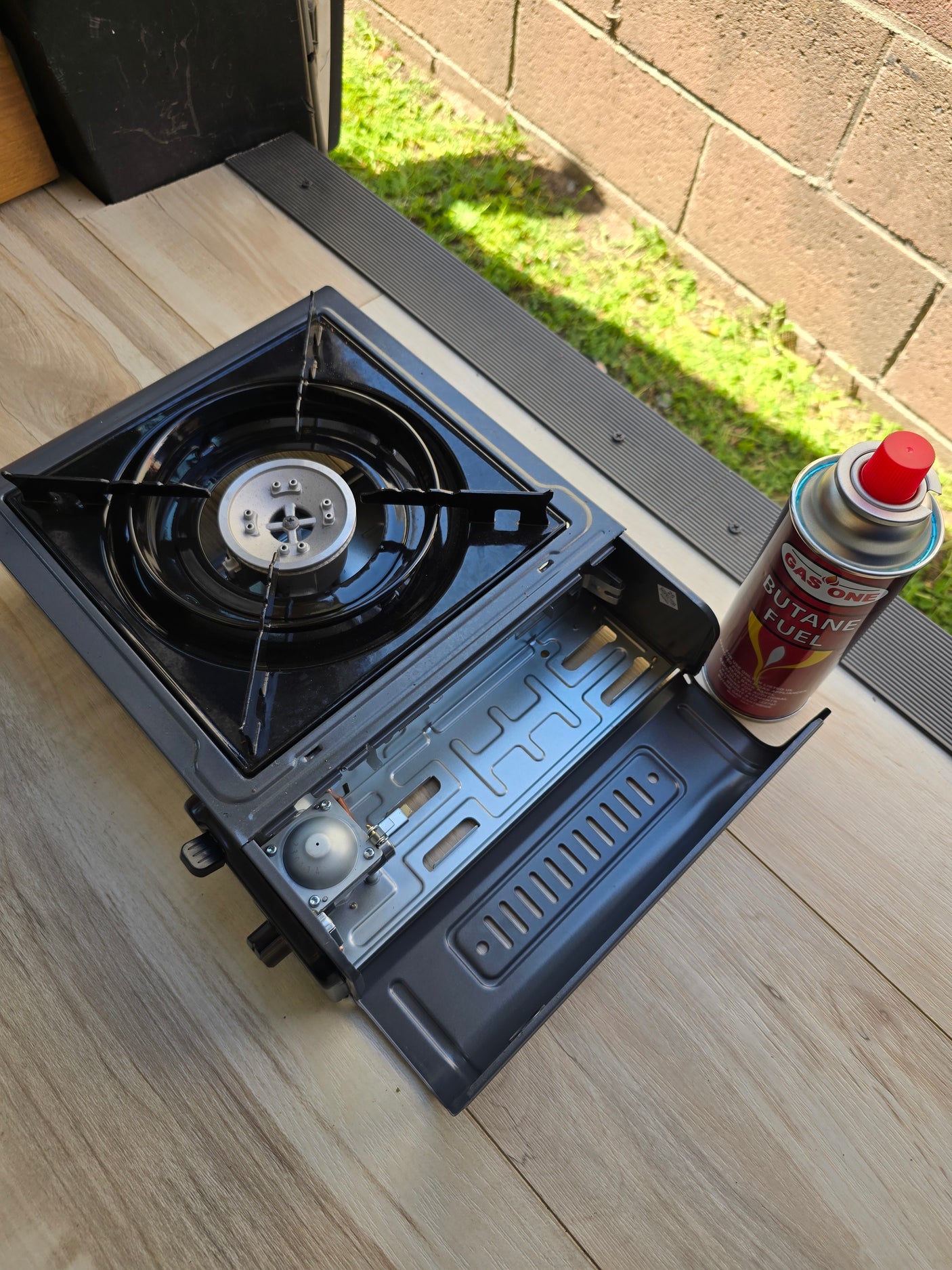 A portable butane stove with fuel can on wood flooring in an rv rental, ready for adventure cooking.