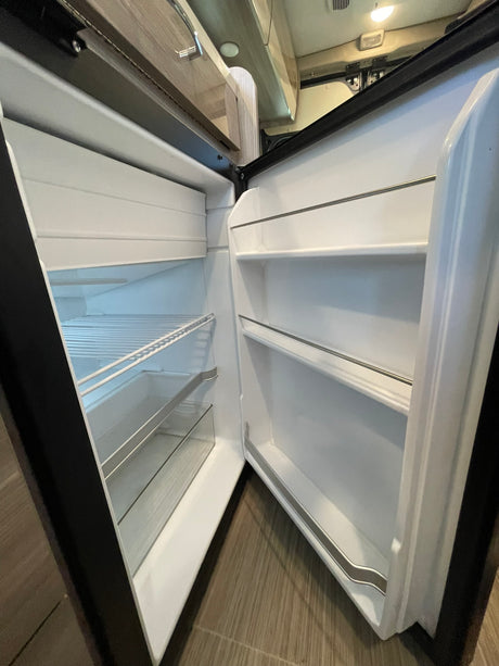 Empty RV rental refrigerator ready for your groceries. Clean shelves & door storage.