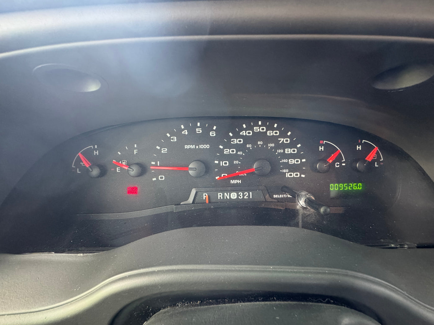 An RV rental's dashboard with speedometer at 0 mph, fuel tank nearly full, odometer showing 95,260 miles, and the BRAKE warning light on. — photo 3
