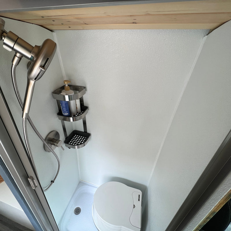 This compact RV rental bathroom features a shower, toiletries caddy, and a space-saving Thetford toilet. — photo 5