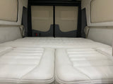Spacious, comfortable white padded bed area within an RV rental, ideal for a relaxing journey and adventure.