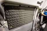 Dark grey quilted window insulation ensures comfort and privacy inside this RV rental, showcasing practical van features.