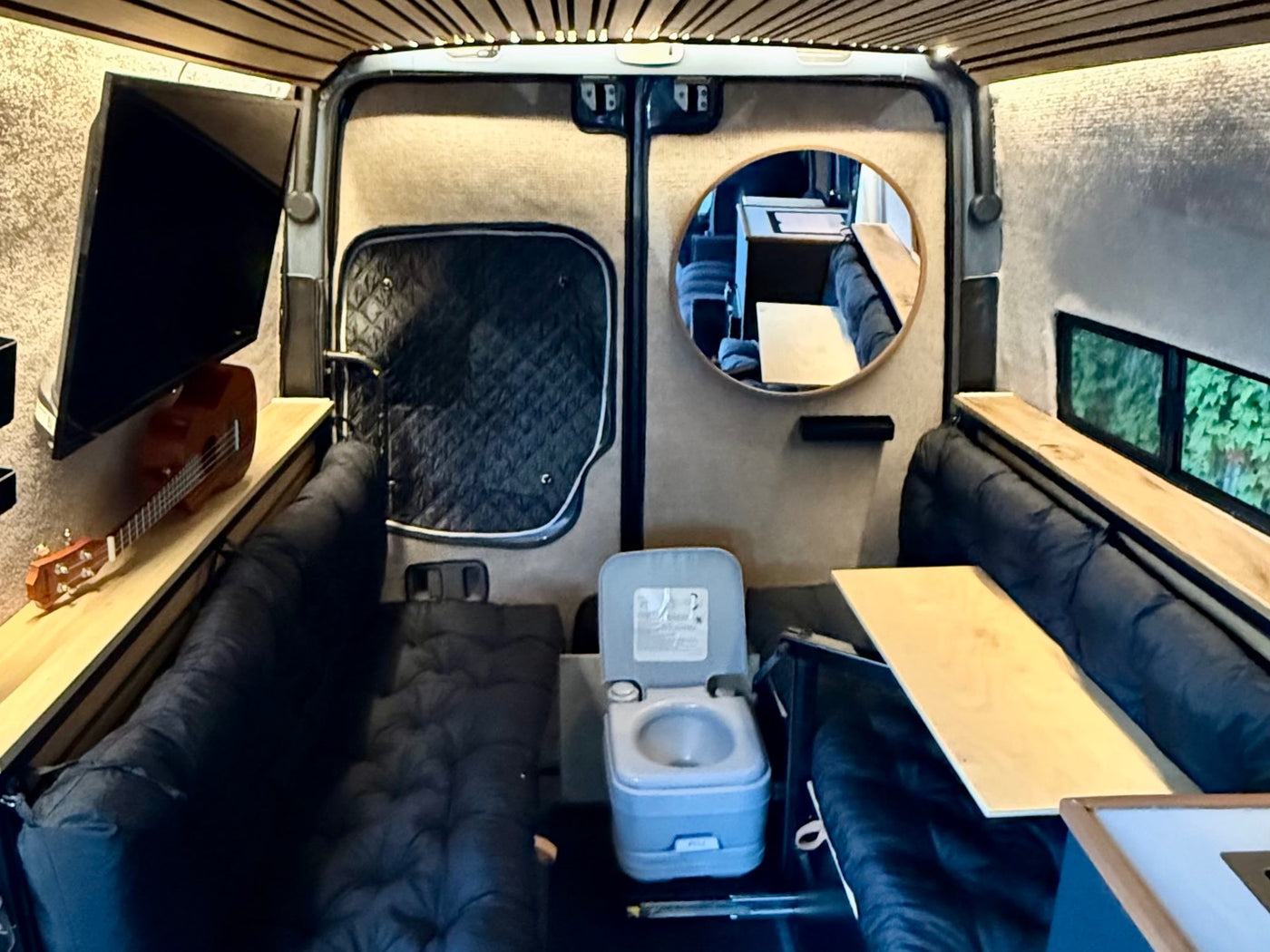  wood-accented camper van.|Inside a cozy RV rental: a comfortable bed with pillows & blanket — photo 16
