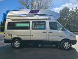 A silver Airstream camper van, perfect for rv rental, featuring a high roof, 'Horizon' awning, and 'AIRSTREAM' badging.
