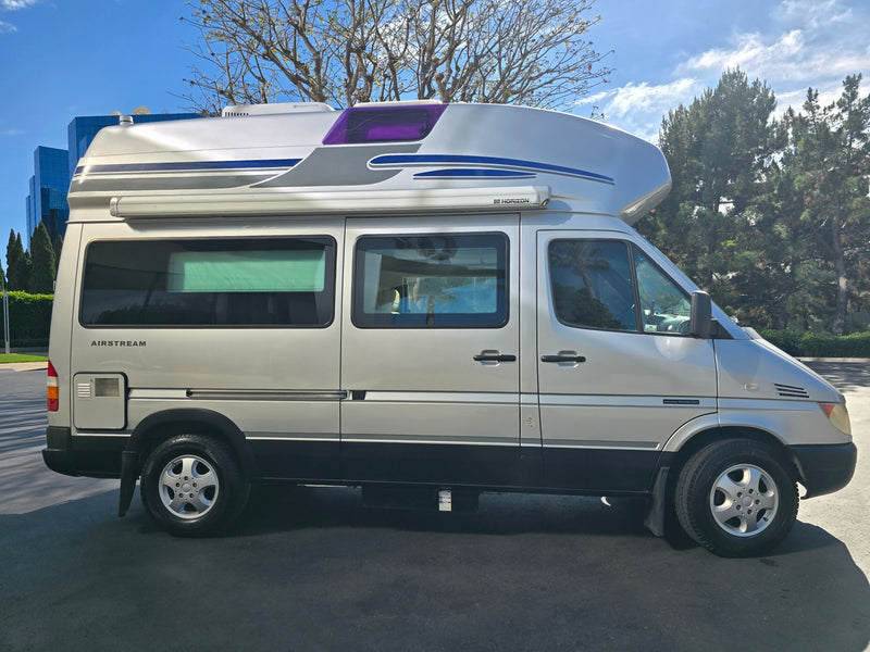 A silver Airstream camper van, perfect for rv rental, featuring a high roof, 'Horizon' awning, and 'AIRSTREAM' badging. — photo 11