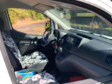 RV rental van interior: blurred view of dashboard, steering wheel, and floral seat covers from passenger side.