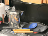 RV rental cooking essentials: a percolator coffee pot, Coleman camping stove, frying pan, and utensils for your outdoor meals.