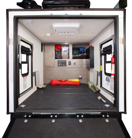 Spacious RV rental toy hauler interior. Features durable floor, side doors, storage, and AC. Perfect for hauling adventure gear.