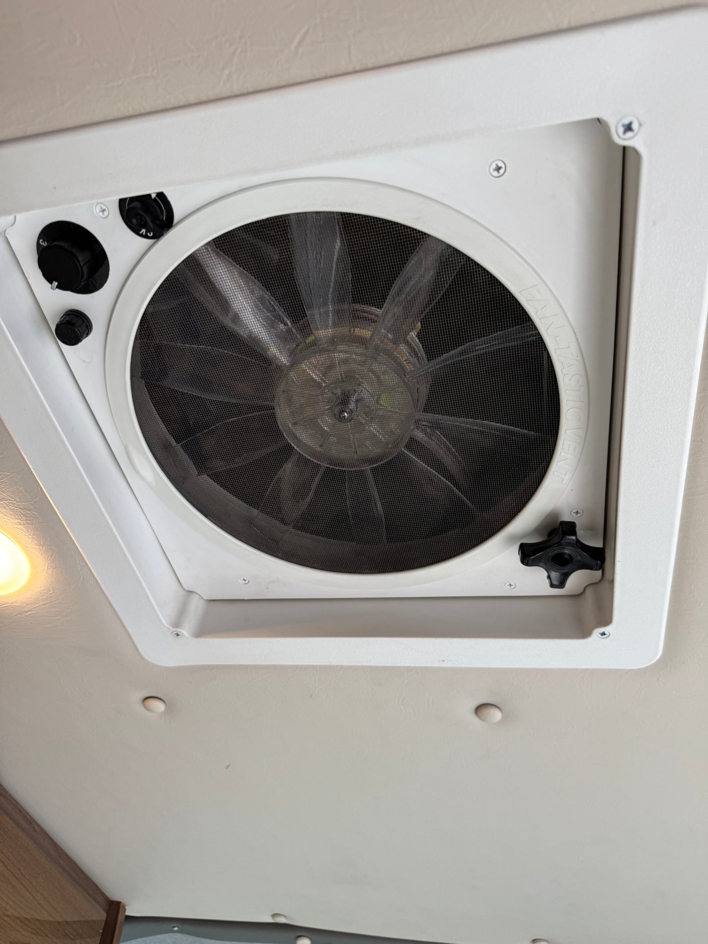 Stay cool in your rv rental with this "FAN-TASTIC VENT" ceiling fan, showing speed controls, a crank, and mesh screen.