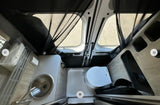 RV rental camper van interior: compact wet bath with toilet, shower pan, sink, and kitchenette area.